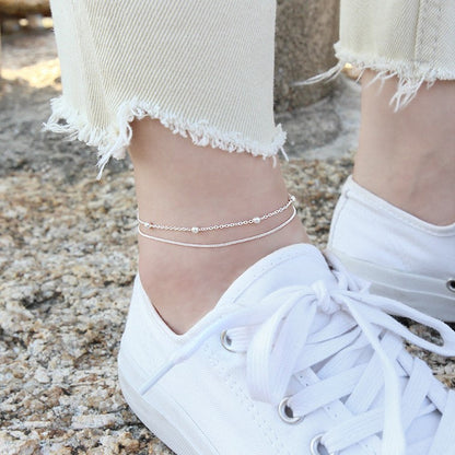 Sidabrinė grandinėlė ant kojos su burbuliukais