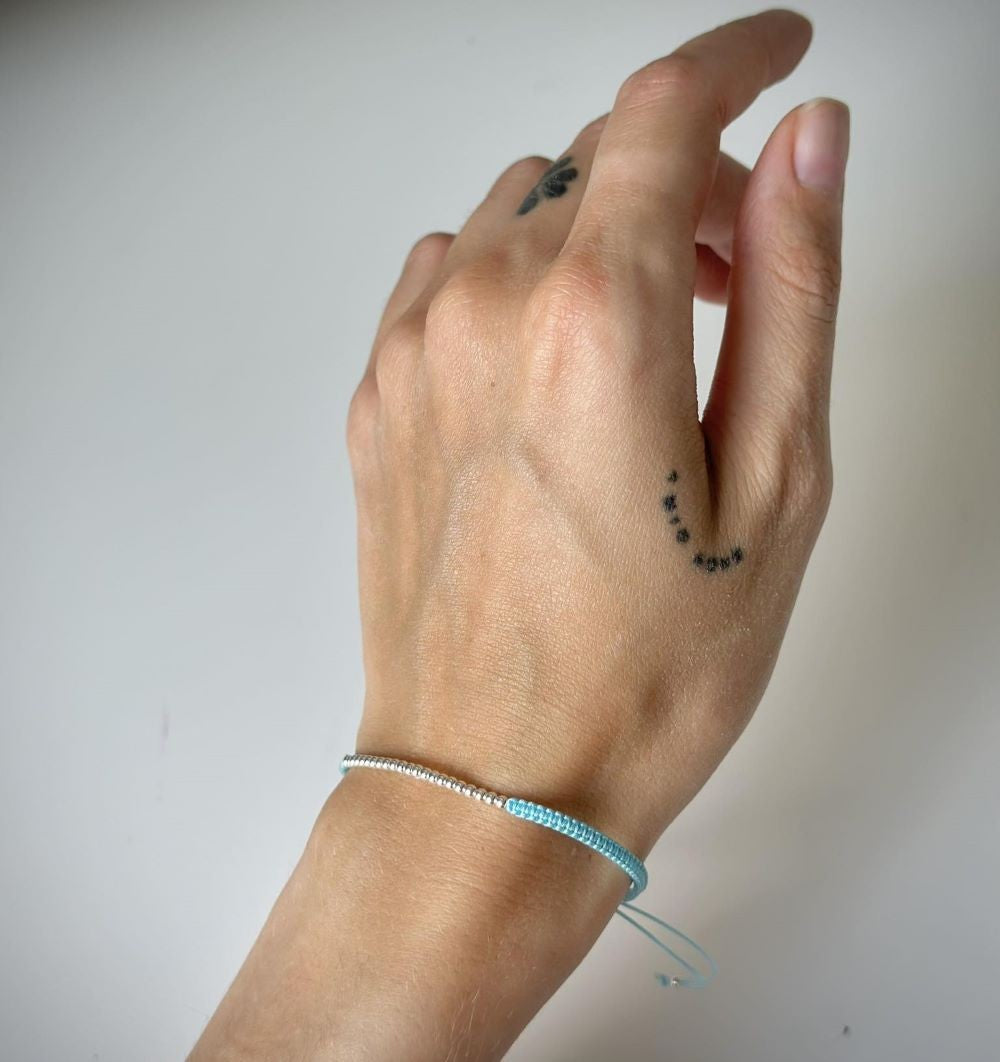 Įvairių spalvų siūlo apyrankės su sidabriniais karoliukais