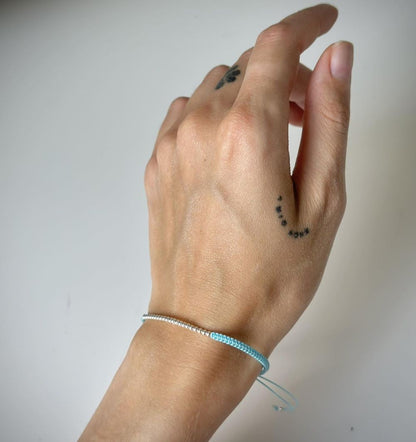 Įvairių spalvų siūlo apyrankės su sidabriniais karoliukais