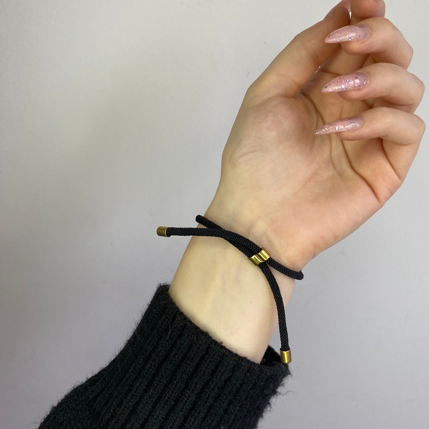 Juodo siūlo apyrankė su plieno detale